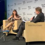 Auf einer Bühne, im Hintergrund steht auf einer Wand "Buch Wien". Im Vordergrund sitzen Constanze Scheib und Günter Kaindlstorfer in großen Polstersesseln, auf denen "Der Standard" steht